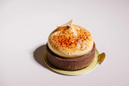 Delicate dessert with a caramelized top on a gold plate against a light background
